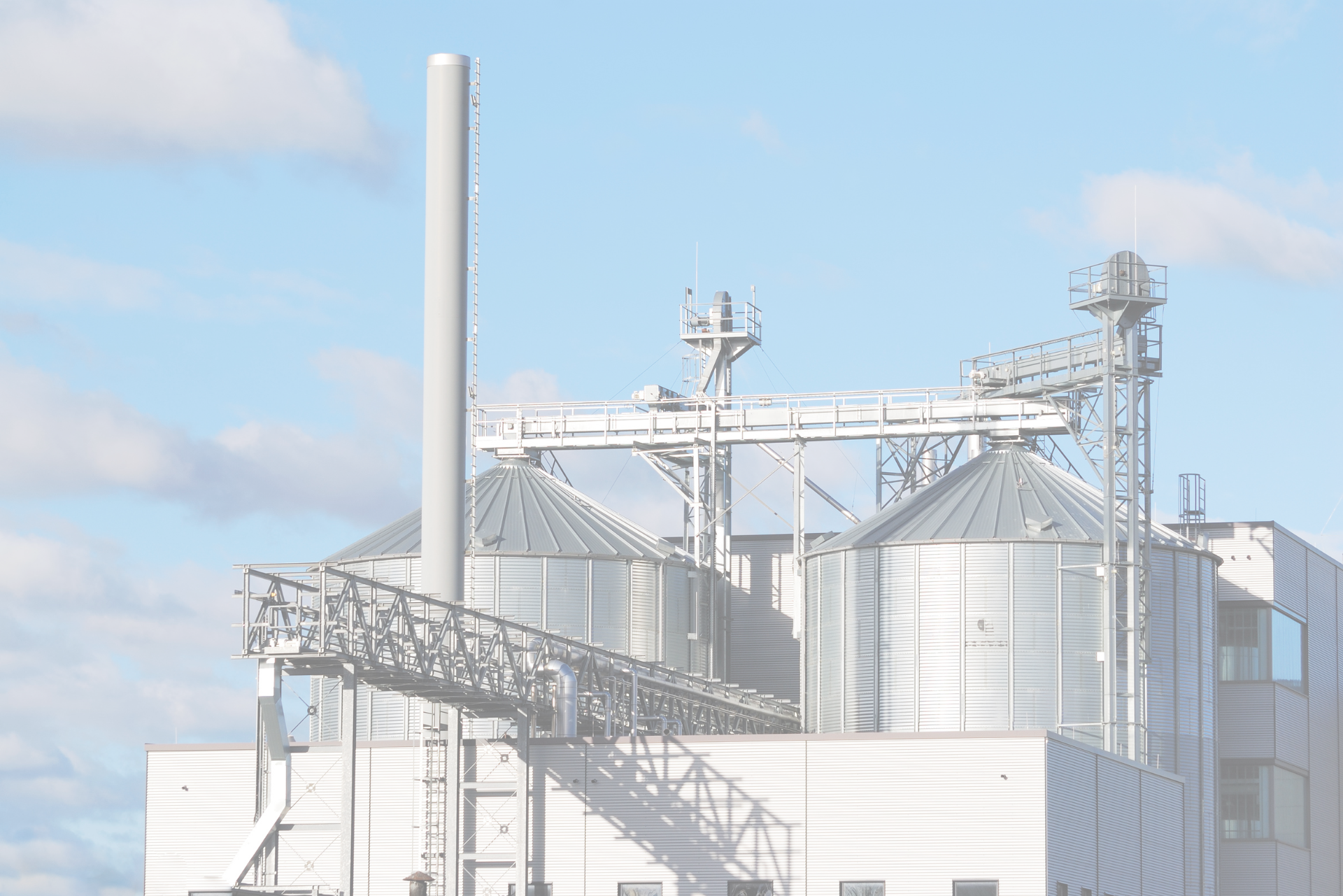 A factory with two large, metal silos.