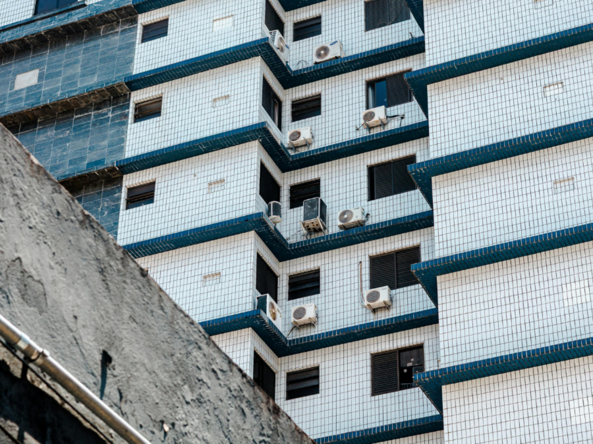 Several air cooling units are installed to the outside wall of a building.