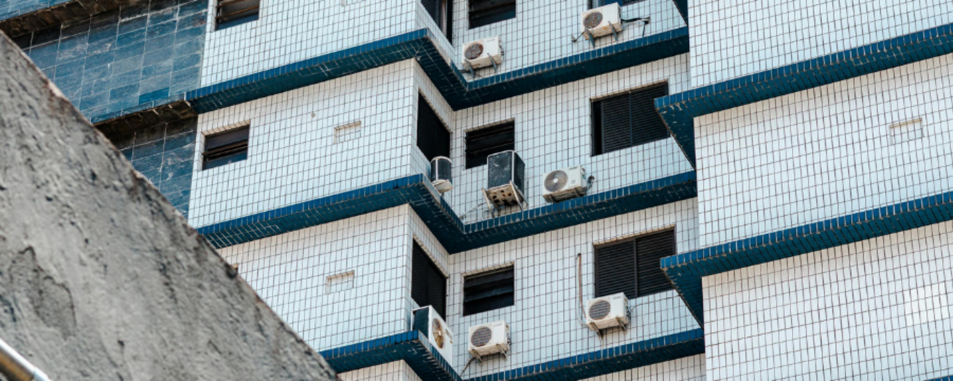 Several air cooling units are installed to the outside wall of a building.