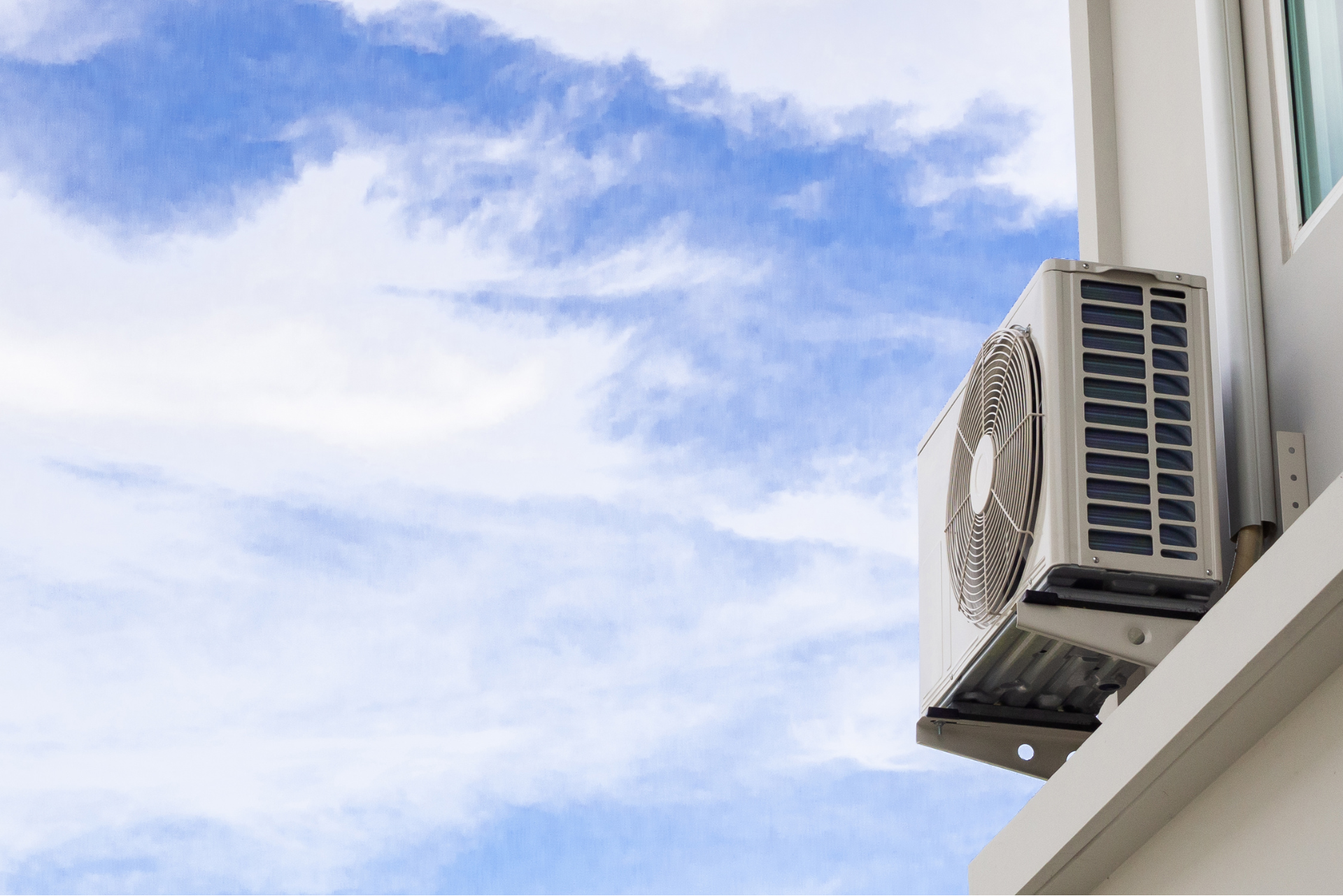 An air cooling unit is installed to the outside wall of a building.
