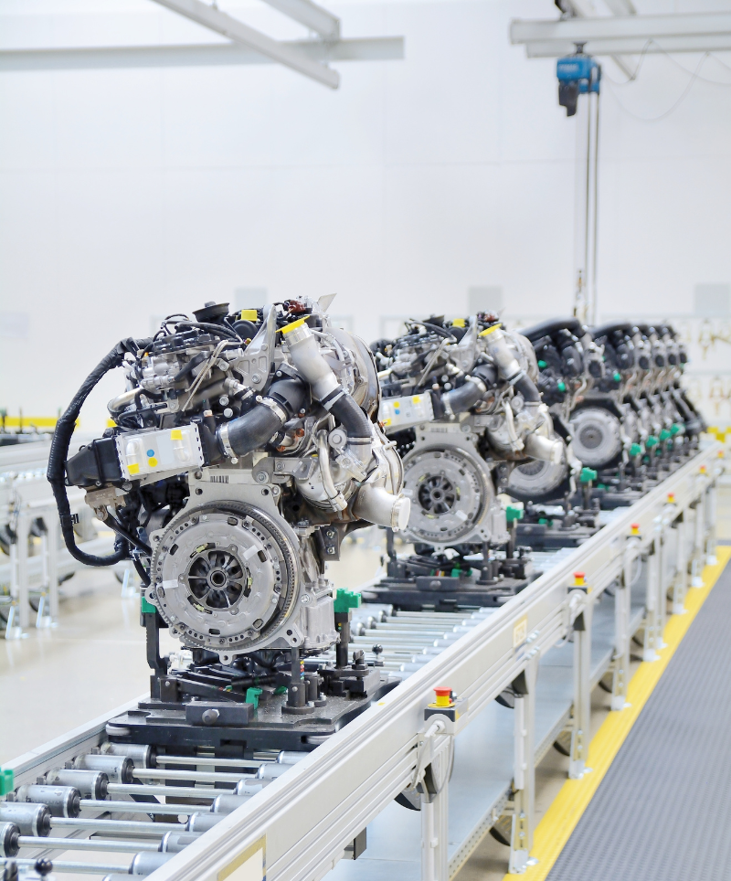 Several robotic machines are lined up on a conveyor belt.