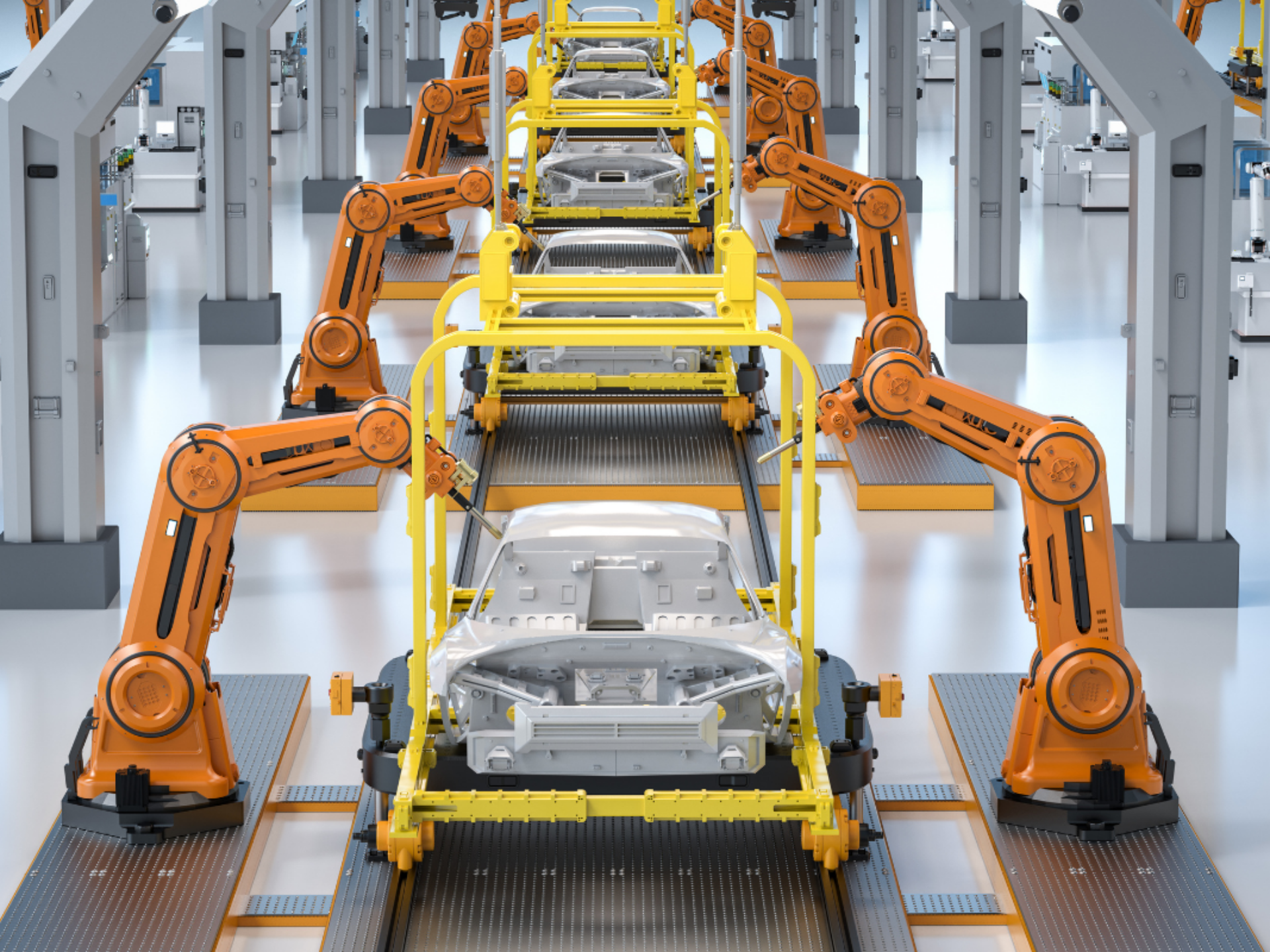 A car production plant. Each car body has two robotic arms working on it.