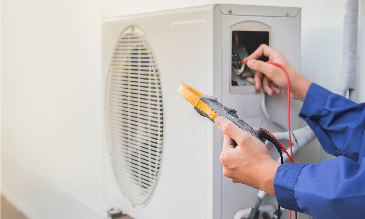 A technician is conducting an electrical test on an air cooling system.
