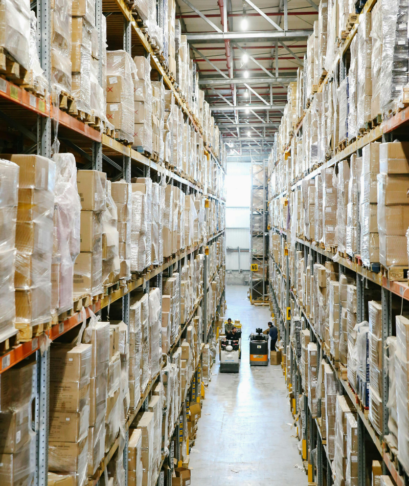 A warehouse with six storey shelves filled with cardboard boxes.